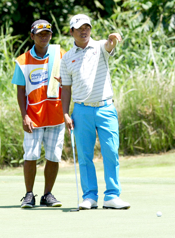 Micah Shin hits his approach shot on No. 17 Jay Bayron checks the line of his putt with his caddie on No. 18