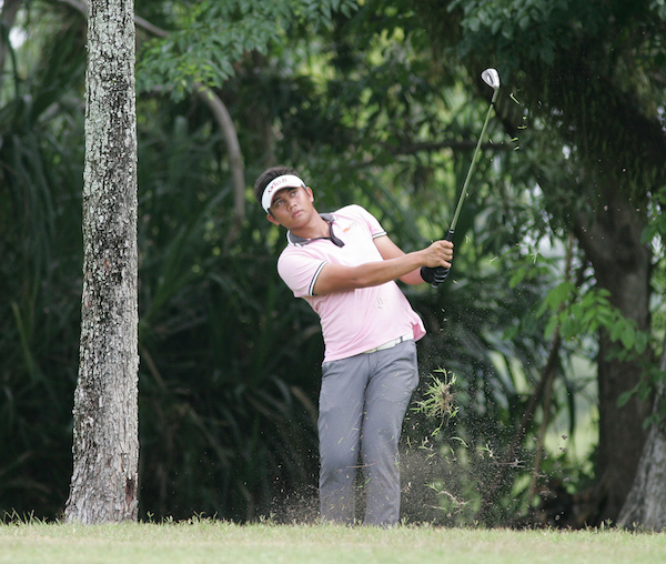 Clyde Mondilla hits an approach shot from under the trees on No. 10