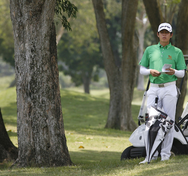 Thai Natthapong Niyomchon weighs his options from a stymied lie on No. 12