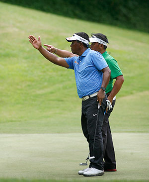 Tony Lascuña and flightmate Joenard Rates complare the lines of their putt on No. 12