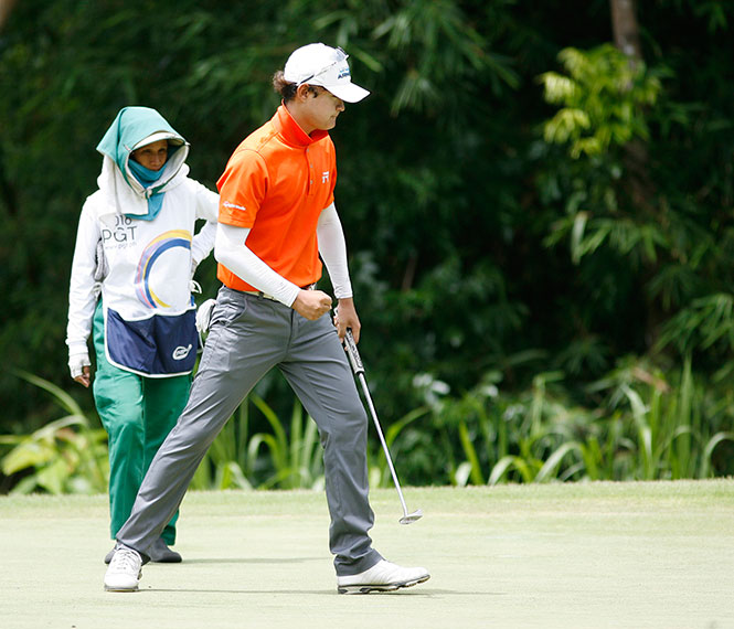 Korean Park Min Ung reacts after sinking a par-saving putt on No. 1