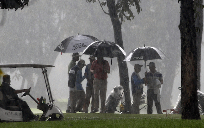 Players take cover as heavy rain stopped play in the opener of the ICTSI TPC Championship at Wack Wack.