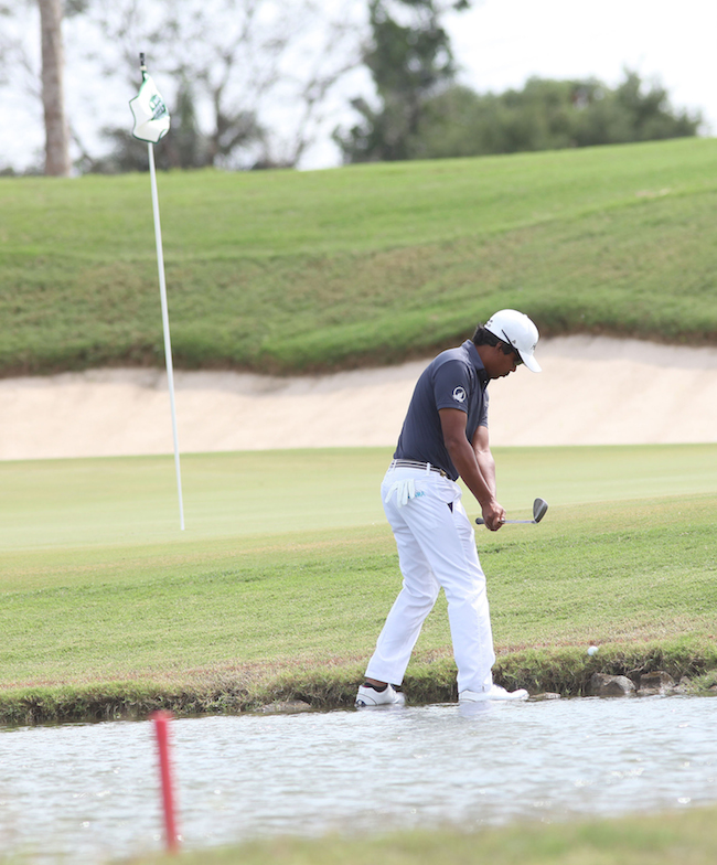 Juvic Pagunsan figures out his shot on a tough lie on the edge of hazard on No. 5